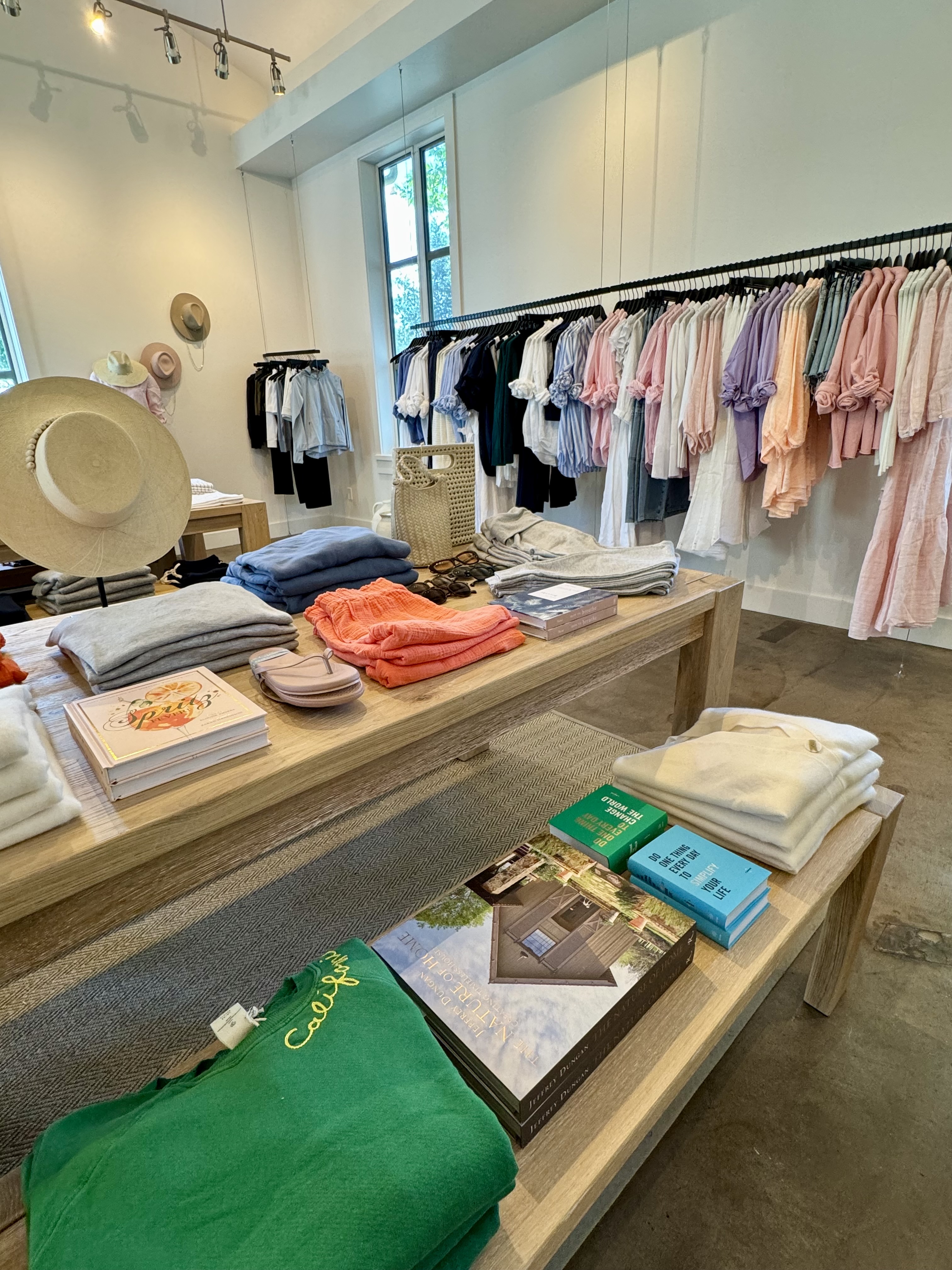 Completed Solage boutique with coordinated apparel rails and styled wood display tables